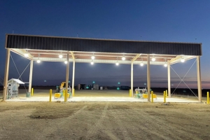 Industrial facility lit up at night with open structure and equipment visible.