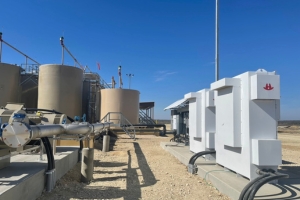 Industrial tanks and equipment with pipes and machinery under a clear blue sky.