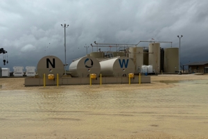 Industrial facility with tanks labeled "N", "O", and "W" under a cloudy sky.