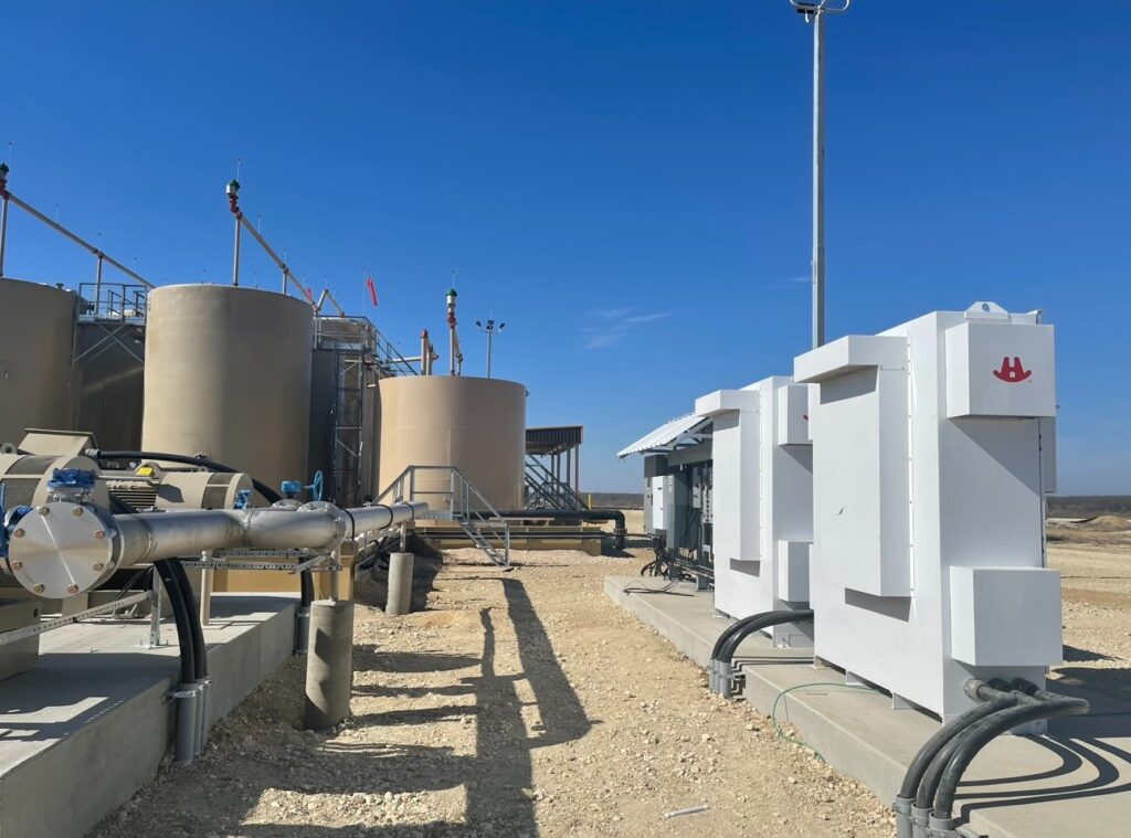Industrial tanks and equipment with pipes and machinery under a clear blue sky.